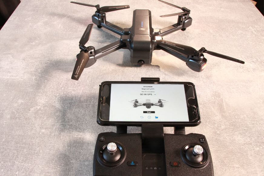 Die Maginon QC 90 Aldi Drohne liegt neben dem Controller auf einem Tisch.